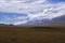 Mountain plateau with ancient mound and cloudy blue sky on background. Rural scenery. Summer nature landscape.