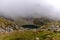 A mountain in the Polish Tatras with a small turquoise lake and rocks in the middle of the mountain