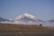 Mountain range covered in snow and fog with meadow slope