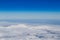 Mountain range emerging from endless white clouds