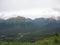 Mountain Range with Forests and Stream. Lush temperate rainforest in alaska with clouds and sun