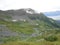 Mountain Range with Forests and Stream. Lush temperate rainforest in alaska with clouds and sun