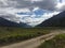 Mountain Range with Forests and Stream. Lush temperate rainforest in alaska with clouds and sun