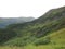 Mountain Range with Forests and Stream. Lush temperate rainforest in alaska with clouds and sun