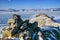 Mountain range with a green texture and rocks covered of snow above the frozen lake