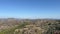 Mountain range with pastures and green trees against a blue horizon