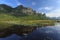 Mountain and reflection in a lake with lotus & typha angustifolia