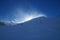 Mountain Ridge covered in snow back-lit by the sun