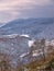 Mountain ridges, red trees and snow covered land