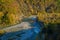 Mountain river across autumnal forest. Water reflections. Autumn nature background