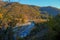 Mountain river across autumnal forest. Water reflections. Autumn nature background