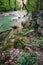 The mountain river Khosta with boulders, stones and pebbles on its sides in springtime. Clear green water of the burly creek in