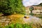 Mountain river with medieval arched bridge in Pyrenees