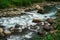 Mountain River rages on rocks on a cloudy day