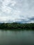 Mountain river in river valley. Summer river bank with blue sky and white clouds. River landscape in Kuala Kubu Baru, Malaysia