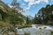 Mountain river water landscape. Alps. The cloudy sky in clear sunny day. Warm summer. Time for pedestrian tourism