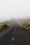 Mountain road with dense mist clouds