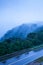 Mountain road in foggy dusk, asphalt road through the mountain top of Phnom Bokor Mountain in rainy day, Preah Monivong Bokor