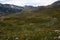 A mountain road leading through rocky meadows and hills