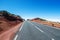 Mountain road over the clouds. Traffic signs `risk of snow` on roadsides. Teide National Park, Tenerife, Canary Islands, Spain