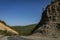 Mountain road serpentine passes through a cliff with beautiful horizontal stripes.