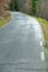 Mountain road with uneven pavement in autumn