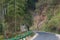 The mountain road is a winding and meandering road that passes through dense forests with lush greenery