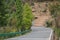 The mountain road is a winding and meandering road that passes through dense forests with lush greenery