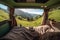 Mountain scenery view as seen from inside a campervan, with legs and a cup of coffee visible in the foreground. Ai generated