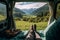 Mountain scenery view as seen from inside a campervan, with legs and a cup of coffee visible in the foreground. Ai generated