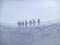 Mountain skiers go together on mountain ridge in snow storm and danger of avalanche, mountain peak Aiguille du Midi in France