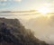 mountain slope above dense clouds at the sunset