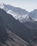 Mountain slope with stone scree against the background of mountain peaks with snow and glaciers