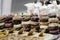 Mountain of small doughnuts decorated differently in an ice-cream display case