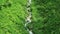 Mountain small stream that flows down from the mountains among the green food. Top view of a mountain stream