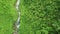 Mountain small stream that flows down from the mountains among the green food. Top view of a mountain stream