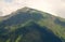 Mountain with steep slopes covered by forest