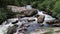 Mountain Stream Cascading and Flowing Around a Large Boulder