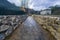 A mountain stream with shores of walls lined with stone boulders in the evening