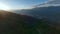 Mountain sunset dive from stone ridge summit valley alpine countryside scenery aerial view