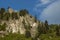 Mountain top overgrown with high trees, rock and glade of Rila mountain