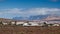 Mountain valley with white buildings and villages between old volcanic slopes. Red Earth and green fields on the background of dee