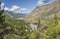 Mountain valley, wild river, green forests. Sunny summer day, blue sky with clouds.