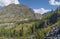 Mountain valley, wild river, green forests. Sunny summer day, blue sky with clouds.