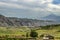 Mountain village at the foot of the Gegham ranges and the silhouette of mount Ararat, covered with haze and layered clouds in the