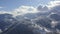 Mountain village on snowy peak on cloudy sky landscape from flying drone. Aerial view winding road in snowy mountain resort. Breat