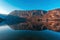 Mountain Vogar in slovenian national park Triglav reflecting its peak in lake Bohinj water in february sunset