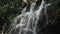 Mountain waterfall flowing down the stones, over the rocks in the forest, a beautiful stream, water splashes from the waterfall fa