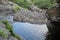 Mountain waterfall. Mountain river among gray huge boulders in the middle of a dense forest