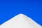 Mountain of white sugar on a blue background